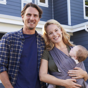 family posing outside of home