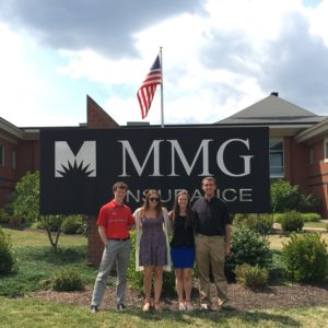 MMG interns posing by sign