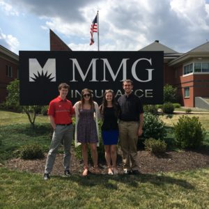 MMG interns posing by sign