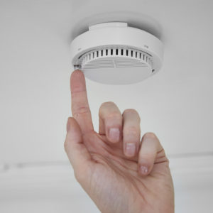 male hand testing smoke alarm